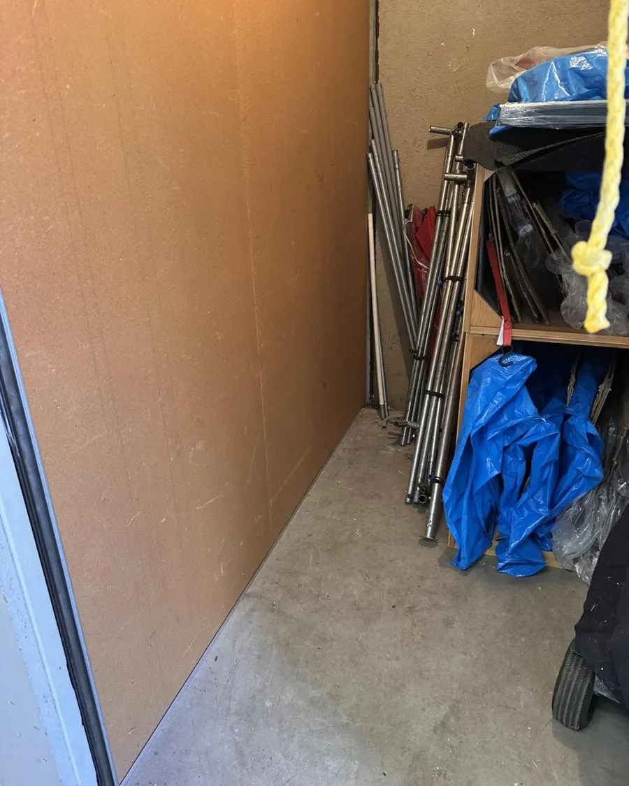 The back wall of the East Denver storage unit cleared, with metal poles and tarps still to go