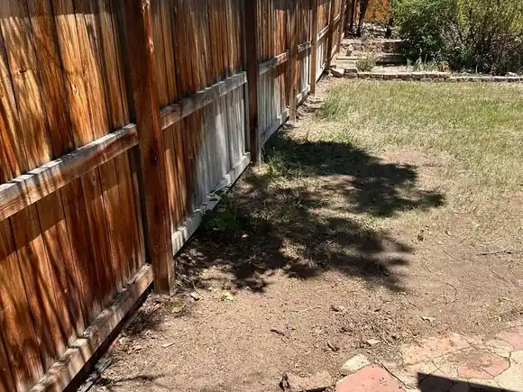 After: the fence line swept clean with the timber pile gone