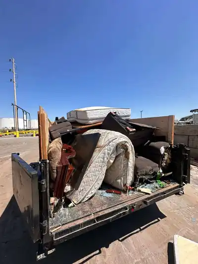 Dump trailer packed with mattresses, furniture and boxes from a full home clear out
