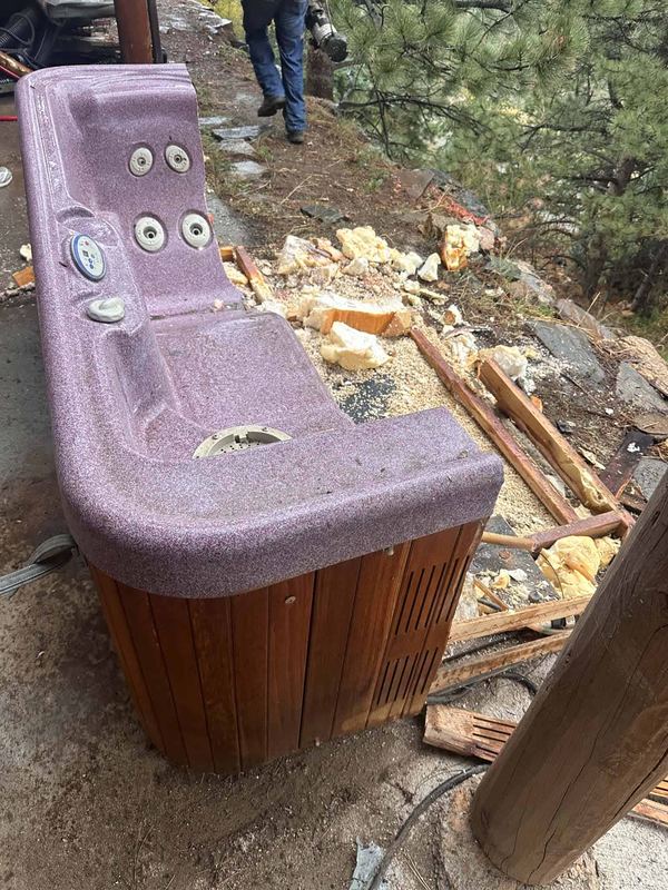 Old hot tub lifted out and stripped down ready to be hauled away from a Colorado back yard
