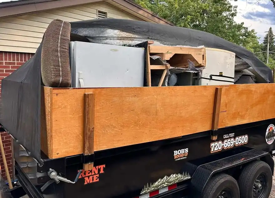 Bob's Round Up dump trailer loaded with household junk on a Colorado driveway